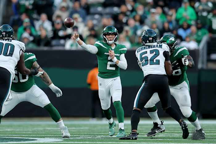 Zach Wilson throws the ball as his o-line blocks two Eagles players